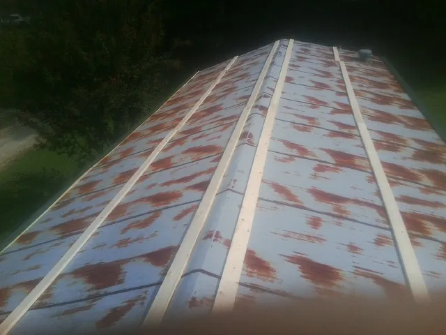 Rusted metal roof panels with new wood purlins before replacement — Storm Damage Roof Repair in Hilltown by Roofing Brothers