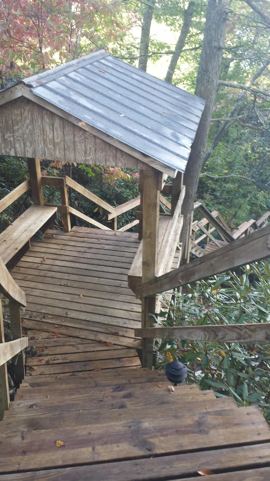 Metal roofed shelter over wooden steps on a wooded walkway — Skylight Repair & Installation work by our crew in Hilltown