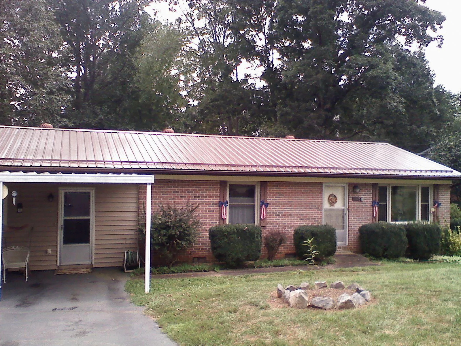 Bronze metal roof and carport on a brick ranch home — Roof Repair work by our crew in Hilltown