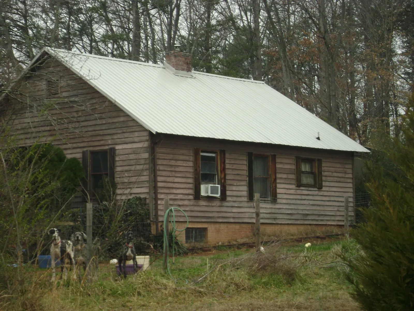White metal roof on an old wood sided farmhouse, from a Metal Roof Installation job in Hilltown